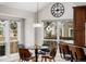 Bright dining area with large windows, a modern light fixture, and dark wood accents at 8827 Cactus Flower Way, Highlands Ranch, CO 80126