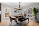 Bright dining room features a modern chandelier, a wooden table, and views from two large windows at 8827 Cactus Flower Way, Highlands Ranch, CO 80126