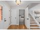 Inviting foyer showcasing hardwood floors, a staircase, and a view into a lower-level storage or basement area at 8827 Cactus Flower Way, Highlands Ranch, CO 80126