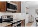 Close up of a stainless steel oven and microwave, set against dark wood cabinetry and granite countertops at 8827 Cactus Flower Way, Highlands Ranch, CO 80126