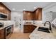 Kitchen with stainless steel appliances, wooden cabinets, granite counters, and white subway tile backsplash at 8827 Cactus Flower Way, Highlands Ranch, CO 80126