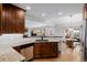 Well-lit kitchen featuring custom wood cabinets, granite countertops, and modern stainless steel appliances at 8827 Cactus Flower Way, Highlands Ranch, CO 80126