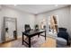 Home office featuring a large black desk, leather chair, and natural light from the windows at 8827 Cactus Flower Way, Highlands Ranch, CO 80126