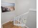 A bright staircase with a wooden railing and a calming seascape photo on the wall at 8827 Cactus Flower Way, Highlands Ranch, CO 80126