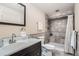 Basement bathroom with shower, toilet and vanity with dark wood cabinets at 11759 E Asbury Ave, Aurora, CO 80014