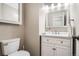 Clean bathroom with white vanity, updated fixtures and a large mirror at 11759 E Asbury Ave, Aurora, CO 80014