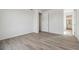 Clean, empty bedroom with modern wood-look flooring, white walls, and an ensuite bathroom at 9062 Telluride Ct, Commerce City, CO 80022