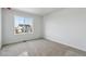 Bright, carpeted bedroom featuring a large window with a neighborhood view at 9062 Telluride Ct, Commerce City, CO 80022