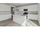 Modern kitchen with white cabinets, stainless steel appliances and a kitchen island with light countertops at 9062 Telluride Ct, Commerce City, CO 80022