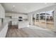 Bright kitchen features white cabinets, an island, stainless appliances, and sliding doors to the backyard at 9062 Telluride Ct, Commerce City, CO 80022