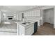 Open kitchen with a center island, stainless steel sink, and view to the living room with a fireplace at 9062 Telluride Ct, Commerce City, CO 80022