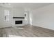 Open living room with wood-look floors, modern fireplace with dark mantle, and bright lighting at 9062 Telluride Ct, Commerce City, CO 80022