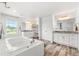 Bright, modern primary bathroom with soaking tub, dual vanities, and wood plank flooring at 4960 Malaya St, Denver, CO 80249