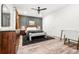 Cozy bedroom features a ceiling fan, gray accent wall, warm lighting, and soft carpet at 4960 Malaya St, Denver, CO 80249