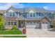Charming two-story home with a stone facade and a well-manicured lawn, complemented by an attached three-car garage at 4960 Malaya St, Denver, CO 80249