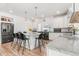 Bright kitchen with white cabinets, an island with bar stools, granite countertops, and stainless steel appliances at 4960 Malaya St, Denver, CO 80249
