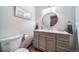 Stylish bathroom featuring a gray vanity with white countertop, round mirror, and modern fixtures at 9745 Derby Way, Parker, CO 80134