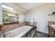 Relaxing bathroom with a soaking tub, tiled accents, and a large mirror at 9745 Derby Way, Parker, CO 80134