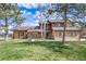 Charming two-story home features a brick and brown siding, landscaped yard, and mature trees at 9745 Derby Way, Parker, CO 80134
