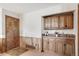 A quaint wet bar with wooden cabinets and rustic decor creates a cozy space for relaxation and entertainment at 9745 Derby Way, Parker, CO 80134