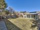 Expansive backyard with a sunroom, deck, lush greenery, and privacy fence at 11002 E Ohio Pl, Aurora, CO 80012