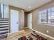 Hallway featuring light-colored walls, hardwood floors, two white doors, and a nearby staircase at 11002 E Ohio Pl, Aurora, CO 80012