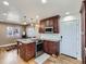 Gourmet kitchen featuring a center island, wood cabinets, granite countertops, stainless steel appliances, and hardwood floors at 11002 E Ohio Pl, Aurora, CO 80012