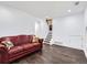 Basement living room featuring hardwood-style flooring and a comfortable red leather sofa at 11002 E Ohio Pl, Aurora, CO 80012