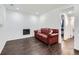 Cozy living room featuring a red leather couch, electric fireplace, and hardwood floors at 11002 E Ohio Pl, Aurora, CO 80012