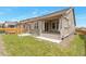 Backyard featuring a covered patio, stone accents, and a well-maintained lawn at 24314 E Ford Ave, Aurora, CO 80018