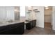 Bathroom featuring dual granite vanities, framed mirrors, and tile flooring leading to a walk-in closet at 24314 E Ford Ave, Aurora, CO 80018