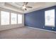Large primary bedroom with a tray ceiling, fan, and multiple windows that provide lots of natural light at 24314 E Ford Ave, Aurora, CO 80018