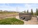 Secluded backyard featuring a modern hot tub, complemented by lush green grass and mature landscaping at 8985 Chalk Creek Pl, Littleton, CO 80125