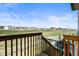 This beautiful backyard view shows a green lawn and houses under a blue sky, seen from a raised wooden deck at 8985 Chalk Creek Pl, Littleton, CO 80125