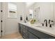 Bathroom featuring double sinks with gray cabinets, white countertops, and modern black hardware at 8985 Chalk Creek Pl, Littleton, CO 80125