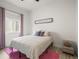 Bright bedroom showcasing a bed with pink accents, light-colored walls, and natural light at 8985 Chalk Creek Pl, Littleton, CO 80125
