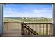 A stunning deck view showcases a verdant field with houses and a mountain range far in the distance, all under a bright sky at 8985 Chalk Creek Pl, Littleton, CO 80125