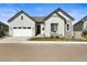 Beautiful exterior showcasing the light-colored facade, a two-car garage, and a welcoming front porch with comfortable seating at 8985 Chalk Creek Pl, Littleton, CO 80125