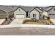 Charming home featuring a well-maintained lawn, driveway, and a cozy front porch, complete with seating and decorative plants at 8985 Chalk Creek Pl, Littleton, CO 80125