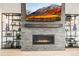 Close up of the fireplace with a stone accent wall, built in shelving, and TV above the mantel at 8985 Chalk Creek Pl, Littleton, CO 80125