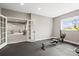 Spacious home gym with rubber flooring and large windows, with rec space in the background at 8985 Chalk Creek Pl, Littleton, CO 80125