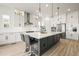 Contemporary kitchen featuring white cabinets, a gray island, stainless steel appliances, and pendant lighting at 8985 Chalk Creek Pl, Littleton, CO 80125
