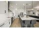 Modern kitchen with white cabinets, stainless steel appliances, and a large center island with bar seating at 8985 Chalk Creek Pl, Littleton, CO 80125