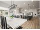 Open concept kitchen and dining room with a large island, stylish pendant lighting, and white cabinetry at 8985 Chalk Creek Pl, Littleton, CO 80125
