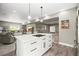 Open layout kitchen with white cabinets, an island with bar seating, and stainless steel appliances overlooking an open living area at 8985 Chalk Creek Pl, Littleton, CO 80125