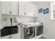 Well-lit laundry room with modern appliances, ample storage, and a utility sink at 8985 Chalk Creek Pl, Littleton, CO 80125