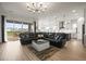 Open floor plan living room leading into the kitchen with lots of natural light and a plush sectional at 8985 Chalk Creek Pl, Littleton, CO 80125
