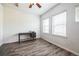 Well-lit bedroom featuring wood-look floors, a ceiling fan, and two windows providing ample natural light at 18726 E Yale Cir # D, Aurora, CO 80013