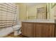 Well-lit bathroom with a bathtub, shower with curtain, and spacious vanity with a large mirror at 5457 S Valdai St, Aurora, CO 80015