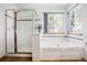 Bright bathroom featuring a shower, soaking tub, and window with natural light at 5457 S Valdai St, Aurora, CO 80015